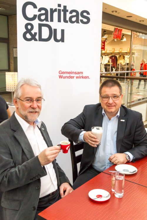 Caritas Direktor Josef Marketz und City-Arkaden-Centermanager Ernst Hofbauer genießen einen “Coffee to help“ (© Foto: caritas-kaernten)