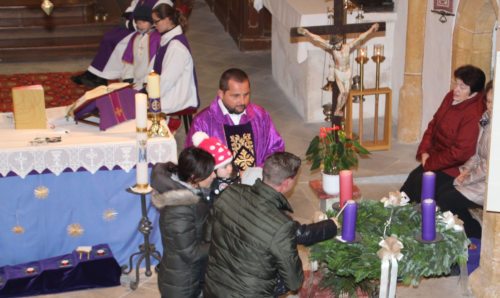 Ein Erstkommunionkind mit Eltern und Schwester beim Anzünden der ersten Adventkerze. (Bild Peter Sternig)