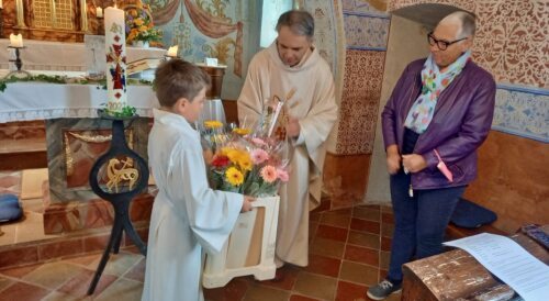 Pfarrer Gabor Köbli und Ministrant Baldur Mölzer übernehmen die von unserer Mesnerin Sigrid Karl organisierten Gerbere<br />
(Foto: Rainer Furlan)