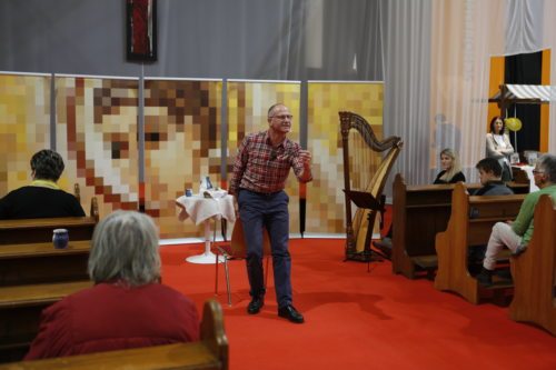 Janko Krištof und Elisabeth Goritschnig bei der Aufführung auf der Herbstmesse. Im Hintergrund ist das Antlitz Christi aus der Kapelle des Bildungshauses Tainach zu sehen. (© Foto: Haab)