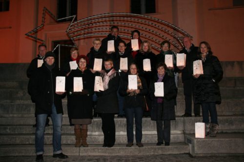 Ein Teil der Chorgemeinschaft vor der Kirche in Griffen: Mit solchen Lichtern können auch die Besucher des Konzertes ihre ganz persönliche Lichtbotschaft in ihre Familien tragen. (© Foto: Walter Konegger)