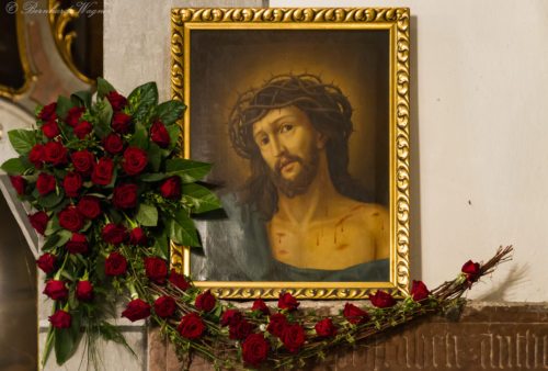 Bildnis des dornengekrönten Hl. Hauptes mit Rosenschmuck am Grabstein neben dem Volksaltar Bildnis des dornengekrönten Hl. Hauptes mit Rosenschmuck am Grabstein neben dem Volksaltar
