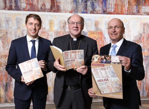 Präsentieren das neue Jahrbuch: Bischof Schwarz mit RLB-Direktor Messner und Pressesprecher Kapeller vor Omans „Requiem für den Homo Sapiens“ in der Seminarkirche Tanzenberg. (© Foto: Pressestelle/Neumüller)