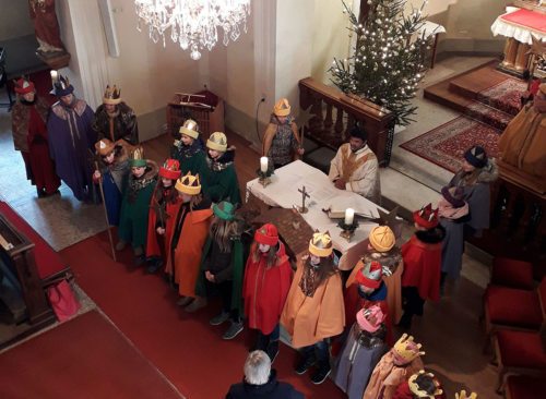 Die Sternsinger stehen um den Altar