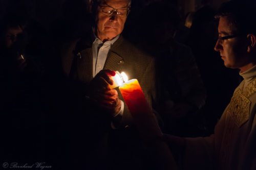 Pfarrprovisor Herr Mag. Dr. Christoph Kranicki übergibt einem Teilnehmer der Osternachtliturgie das Osterlicht (© Foto: Mag. Bernhard Wagner)