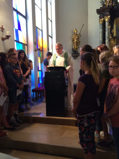Stadtpfarrer Dr. Jakob Ibounig während des Evangeliums umgeben vom Jugendchor. (© Foto: Mag. Ulrich Kogler)