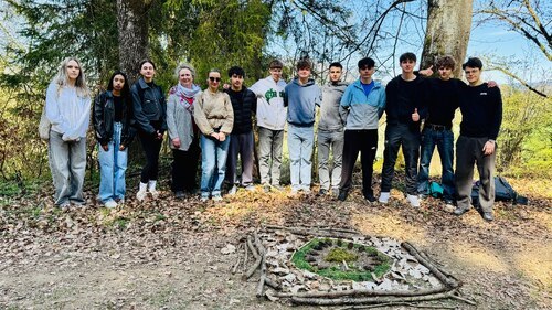 Schüler*innen mit dem selbstgelegten Mandala aus Naturmaterialien (Foto: Carmen Heller)