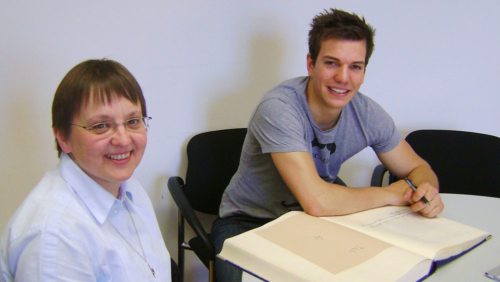 Paralympics-Sieger Markus Sacher trägt sich in die Schulchronik ein. (© Foto: RG/ ORG St. Ursula Klagenfurt)