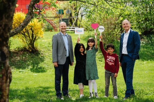 Stefan Rohringer (links), Leiter des Infineon Entwicklungszentrums Graz, und Oliver Heinrich, Finanzvorstand Infineon Technologies Austria, besuchten die Kinder beim Spielen im Garten.<br />
 (Foto: © Infineon Austria)