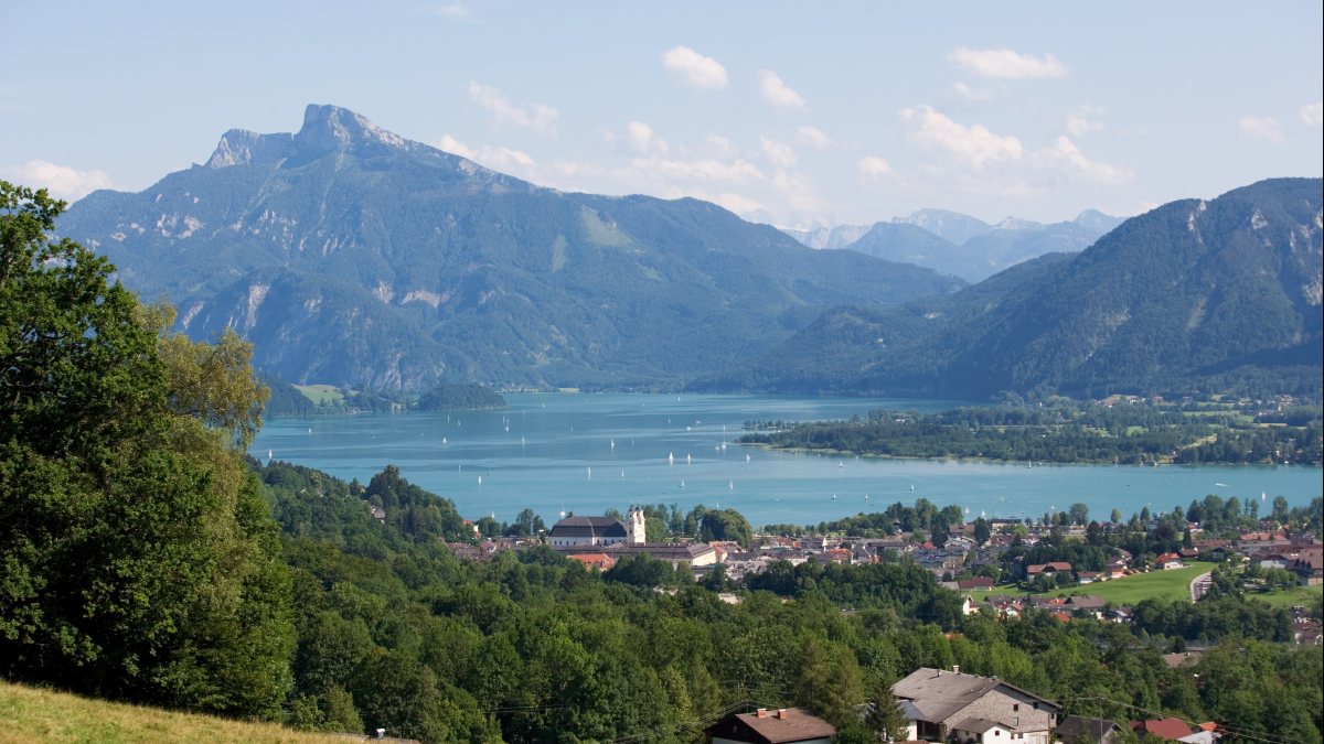 Blick auf den Mondsee und das ehemalige Kloster mit der Basilika (Gemeinfrei:von TVB Mondsee - Irrsee[CC BY 2.0 (https://creativecommons.org/licenses/by/2.0)], via Wikimedia Commons)