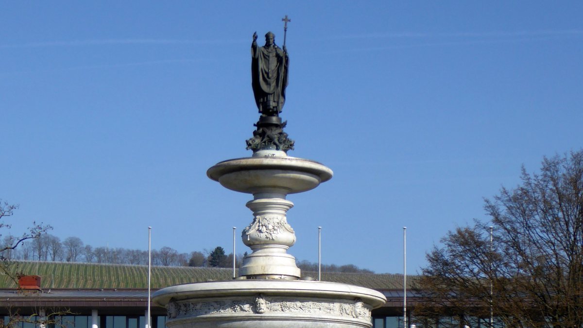 Würzburg, Kiliansbrunnen auf dem Bahnhofplatz. (von Aisano [GFDL (http://www.gnu.org/copyleft/fdl.html)  (https://creativecommons.org/licenses/by-sa/3.0)], vom Wikimedia Commons)